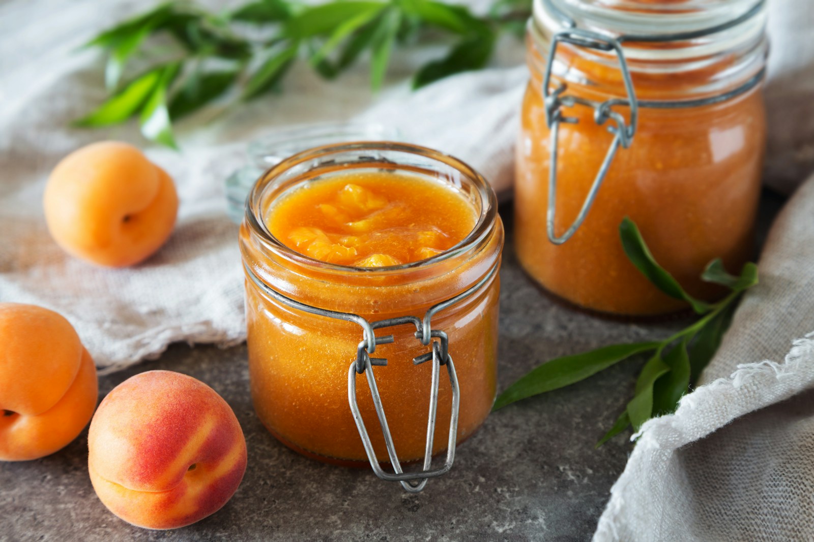 a jar of orange juice next to a jar of oranges